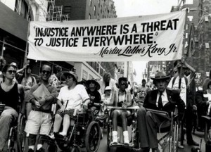 ADA members holding a banner that reads: injustice anywhere is a threat to justice everywhere.